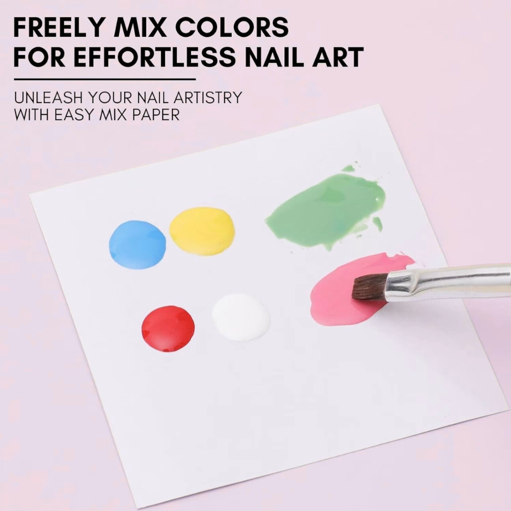 Nail art mixing paper with colorful dots and a brush on a pink background