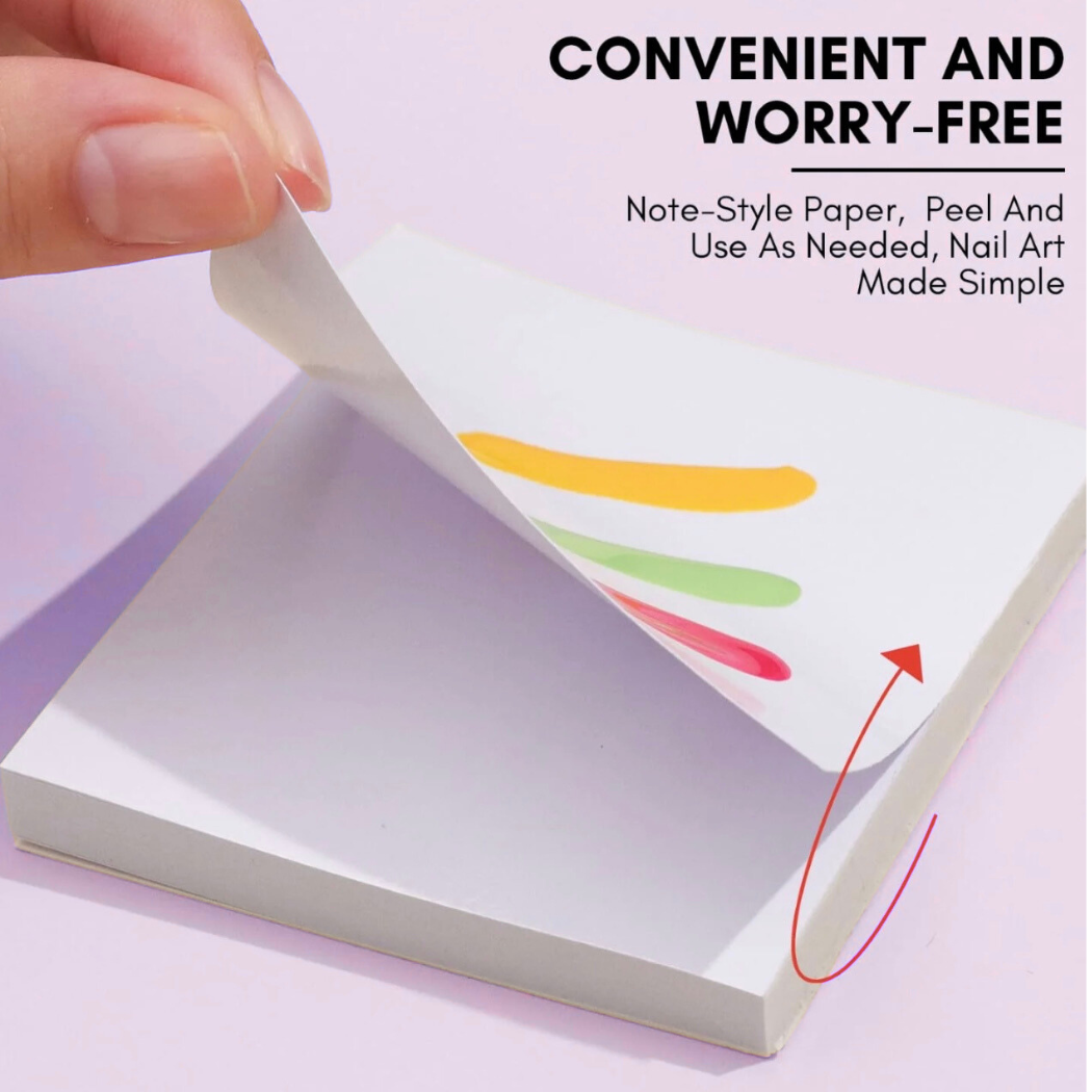 Note-style paper being peeled from a small book with colorful designs on a pink background.
